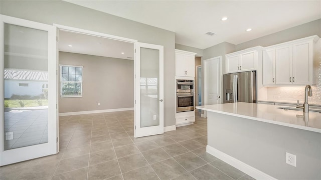 kitchen featuring light tile patterned floors, white cabinetry, sink, and appliances with stainless steel finishes