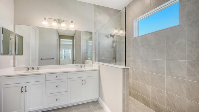 bathroom with tile patterned floors, vanity, and tiled shower