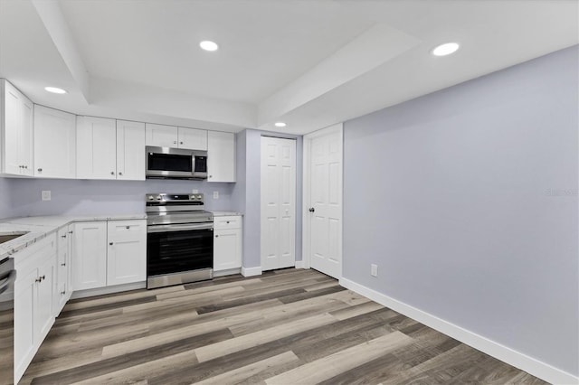 kitchen with baseboards, recessed lighting, stainless steel appliances, light wood-style floors, and white cabinetry