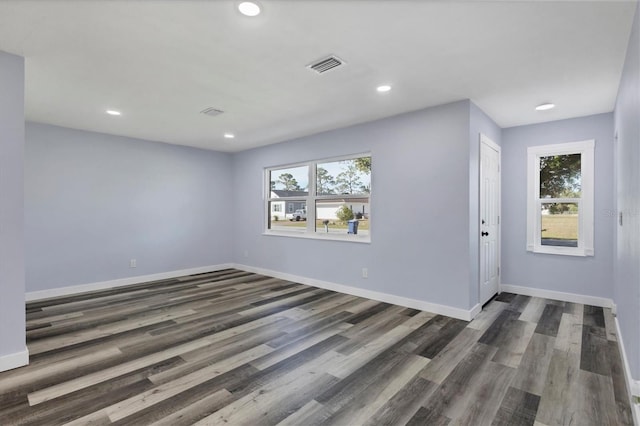 spare room featuring visible vents, recessed lighting, dark wood-type flooring, and baseboards