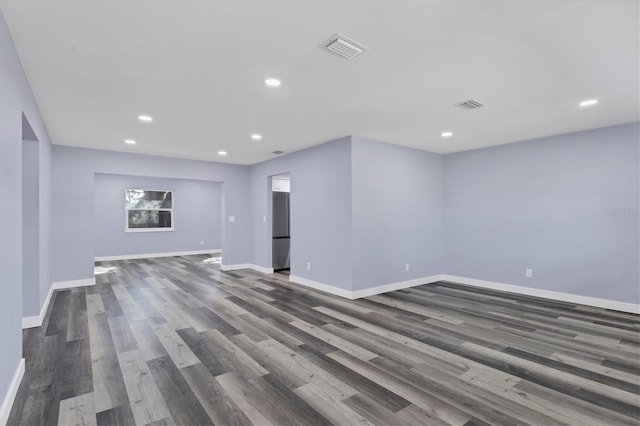 spare room featuring dark wood-style floors, visible vents, recessed lighting, and baseboards