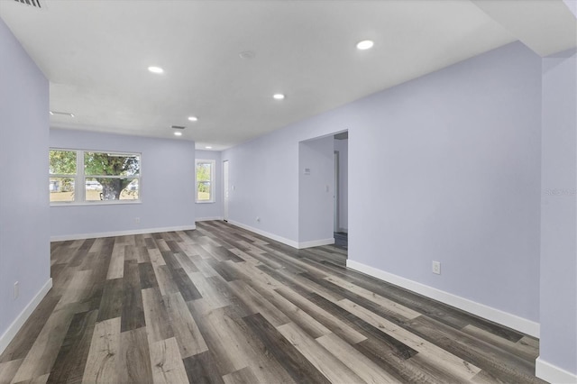 empty room with dark wood-type flooring, recessed lighting, baseboards, and visible vents