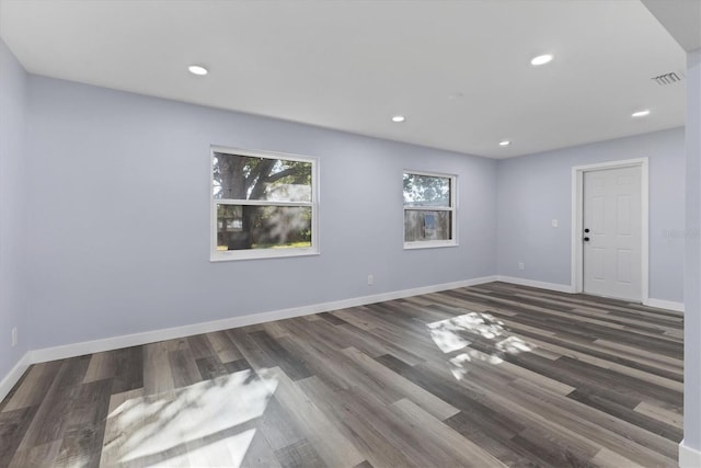 spare room featuring wood finished floors, recessed lighting, baseboards, and visible vents