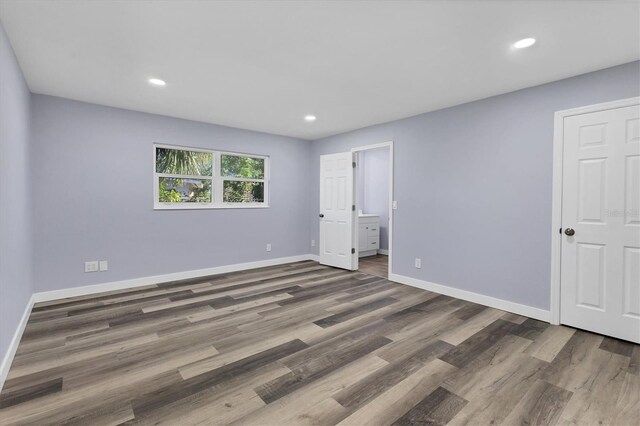 unfurnished bedroom with recessed lighting, baseboards, and wood finished floors