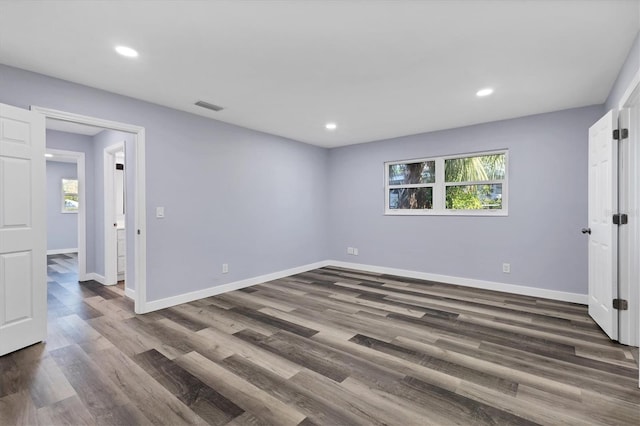 spare room with visible vents, recessed lighting, dark wood-type flooring, and baseboards