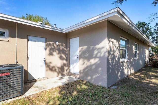 exterior space featuring cooling unit and stucco siding