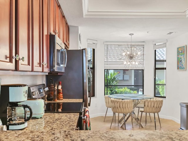 kitchen with decorative light fixtures, a healthy amount of sunlight, appliances with stainless steel finishes, and an inviting chandelier