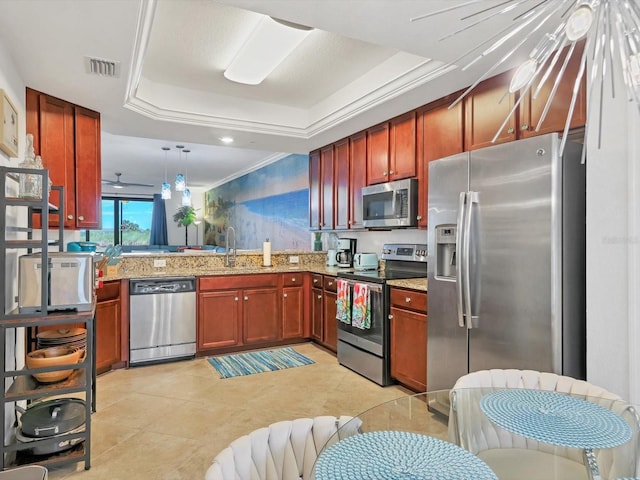 kitchen featuring sink, hanging light fixtures, kitchen peninsula, a tray ceiling, and appliances with stainless steel finishes