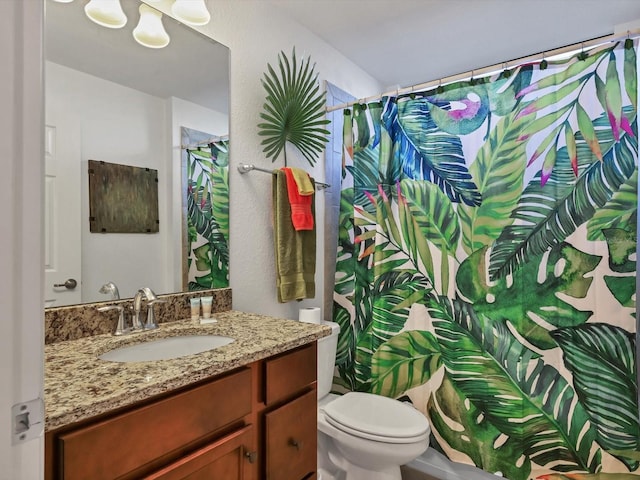 bathroom with vanity, toilet, and walk in shower