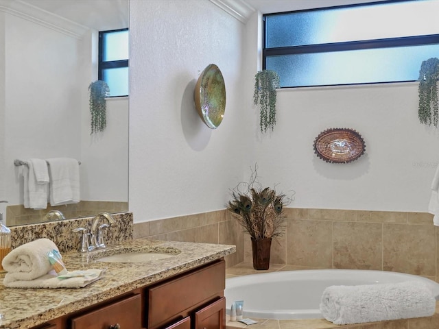 bathroom with vanity, ornamental molding, and a bath