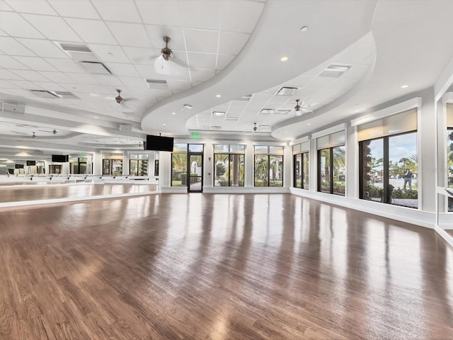 exercise room featuring a paneled ceiling, ceiling fan, and wood-type flooring