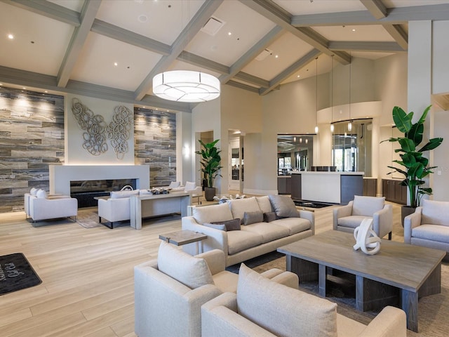 living room featuring beam ceiling, light wood-type flooring, and high vaulted ceiling