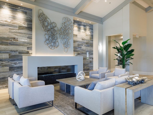 living room with beamed ceiling, a high ceiling, and light hardwood / wood-style flooring