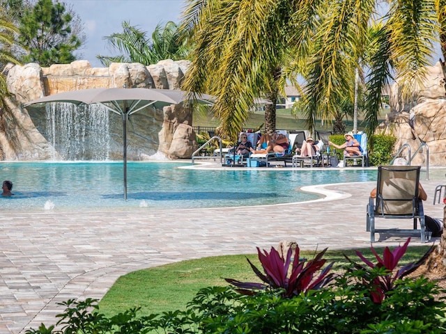 view of swimming pool with pool water feature