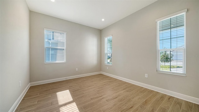 spare room with light wood-type flooring and a healthy amount of sunlight