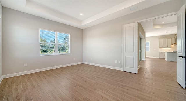 10142 Crystal Isles Cir, Sarasota, FL 34241 - spare room featuring a raised ceiling, light wood finished floors, and recessed lighting