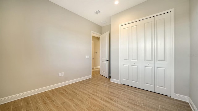 unfurnished bedroom featuring light wood-type flooring and a closet