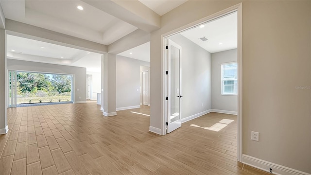 hall with a healthy amount of sunlight and light wood-type flooring