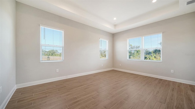 10142 Crystal Isles Cir, Sarasota, FL 34241 - empty room with wood finished floors, a raised ceiling, and recessed lighting