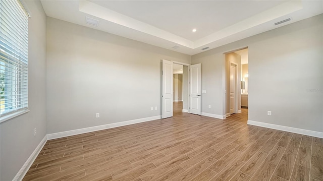 10142 Crystal Isles Cir, Sarasota, FL 34241 - unfurnished bedroom with light wood-type flooring, a raised ceiling, connected bathroom, and recessed lighting