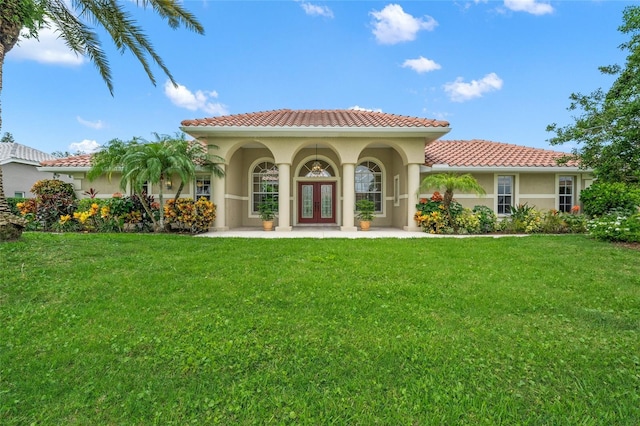 back of property with a lawn and french doors