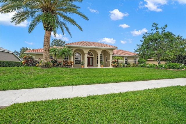 mediterranean / spanish home with a front yard