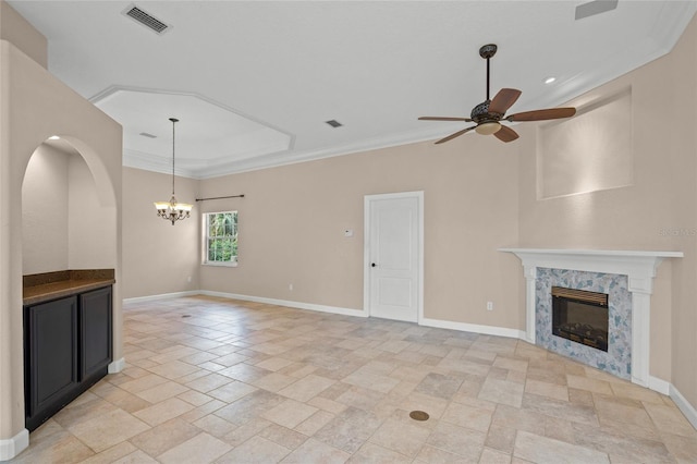 unfurnished living room with a premium fireplace, ceiling fan with notable chandelier, and ornamental molding