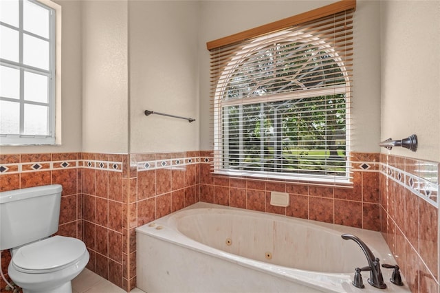 bathroom with toilet, a wealth of natural light, a tub, and tile walls