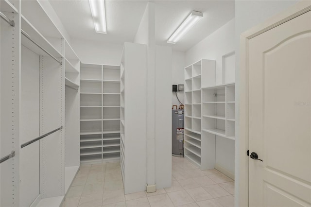 walk in closet featuring electric water heater and light tile patterned floors