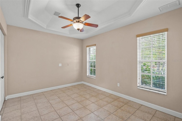 unfurnished room featuring ceiling fan, light tile patterned floors, ornamental molding, and a tray ceiling