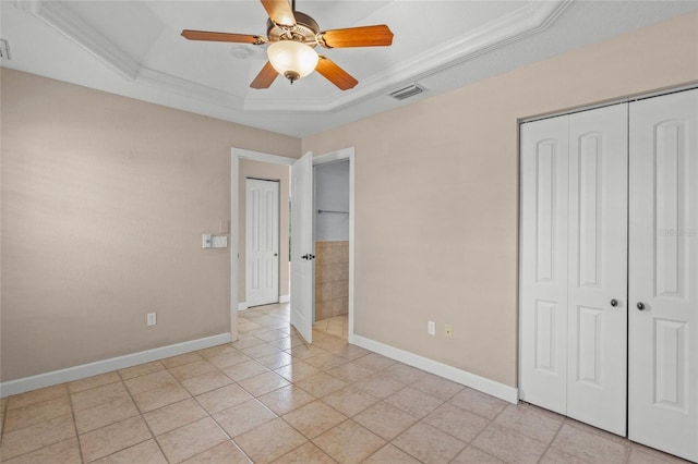 unfurnished bedroom with ceiling fan, light tile patterned floors, crown molding, and a tray ceiling