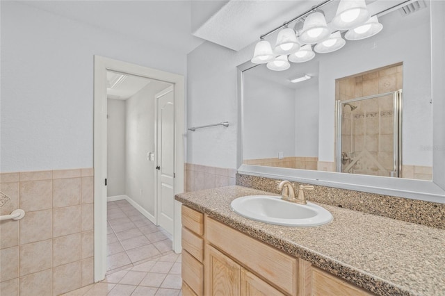 bathroom featuring tile patterned flooring, vanity, and a shower with door