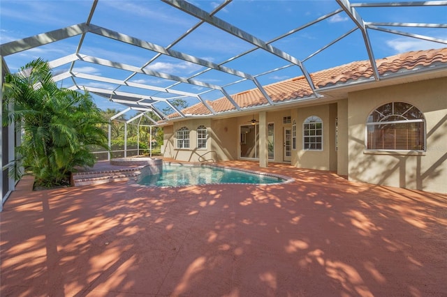 view of swimming pool with glass enclosure, ceiling fan, and a patio