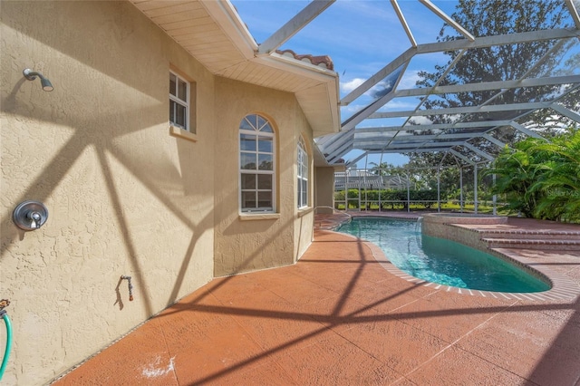 view of swimming pool with a patio and a lanai