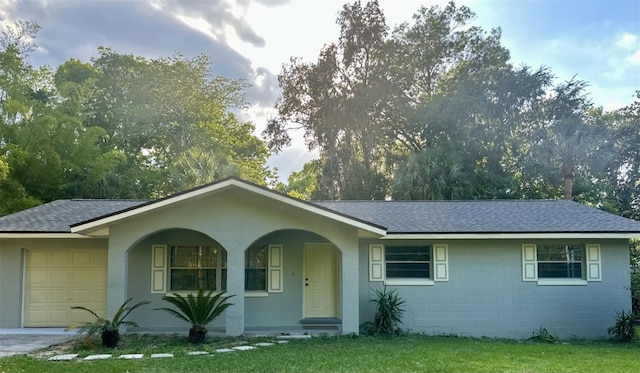 single story home with a front yard, a porch, and a garage