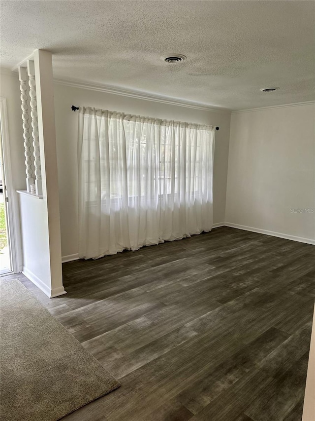 empty room with a textured ceiling and dark hardwood / wood-style floors