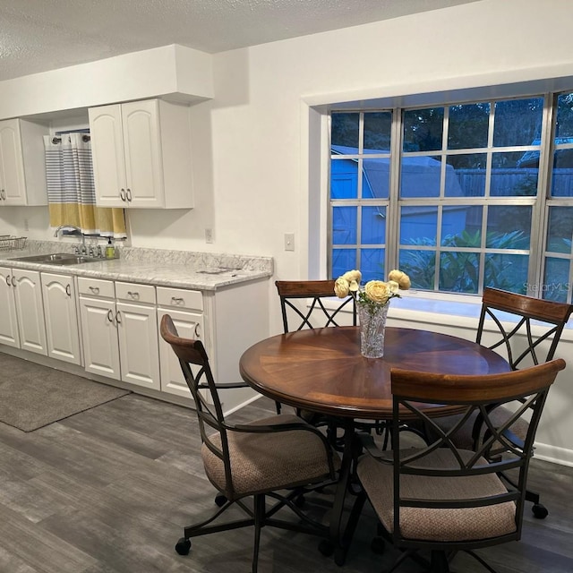 dining area featuring dark hardwood / wood-style flooring, a textured ceiling, and sink