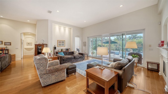 living room featuring a high ceiling and light hardwood / wood-style floors