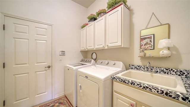 clothes washing area featuring sink, cabinets, and independent washer and dryer