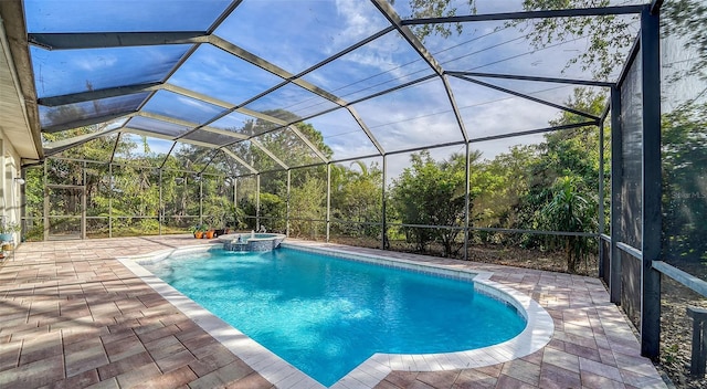 view of swimming pool with glass enclosure, an in ground hot tub, and a patio