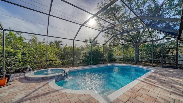 view of pool with a patio area, an in ground hot tub, pool water feature, and glass enclosure