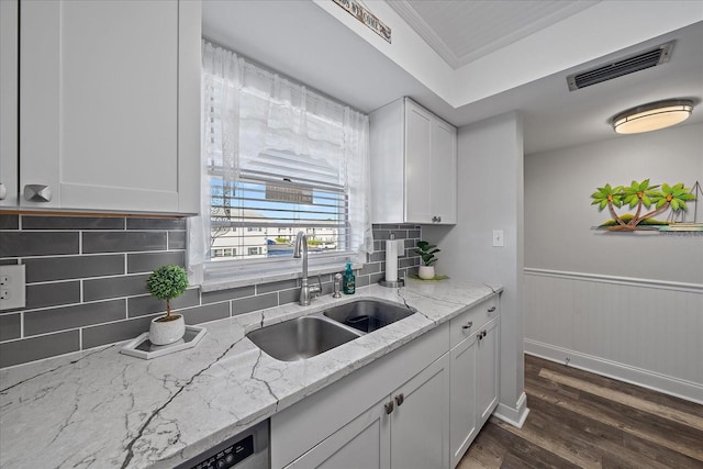 kitchen with light stone countertops, backsplash, sink, dark hardwood / wood-style floors, and white cabinetry