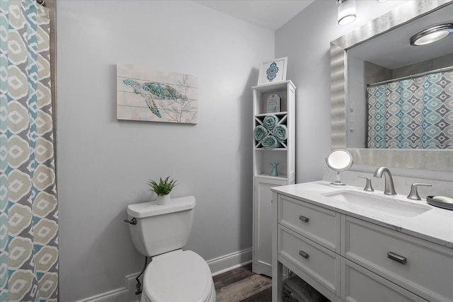 bathroom with hardwood / wood-style floors, vanity, and toilet