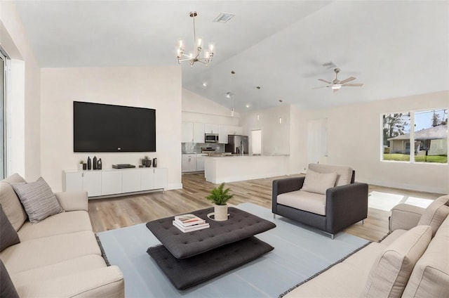 living room with high vaulted ceiling, ceiling fan with notable chandelier, and light wood-type flooring