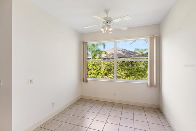 spare room with ceiling fan, light tile patterned flooring, and a wealth of natural light