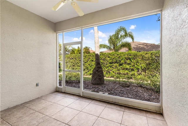 unfurnished sunroom featuring ceiling fan