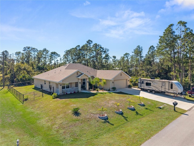 ranch-style home with driveway, an attached garage, fence, and a front lawn