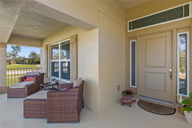 doorway to property featuring covered porch and stucco siding