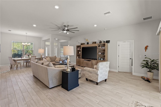 living area featuring ceiling fan with notable chandelier, light wood-type flooring, visible vents, and recessed lighting