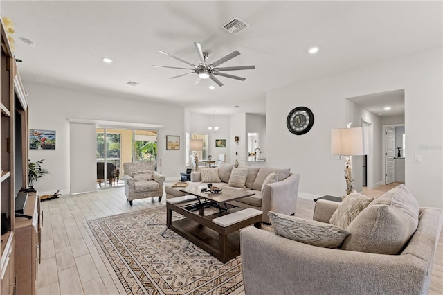 living area featuring ceiling fan with notable chandelier, light wood-type flooring, visible vents, and recessed lighting